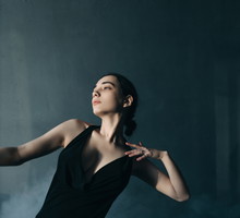 Young beautiful woman dancing in foggy room