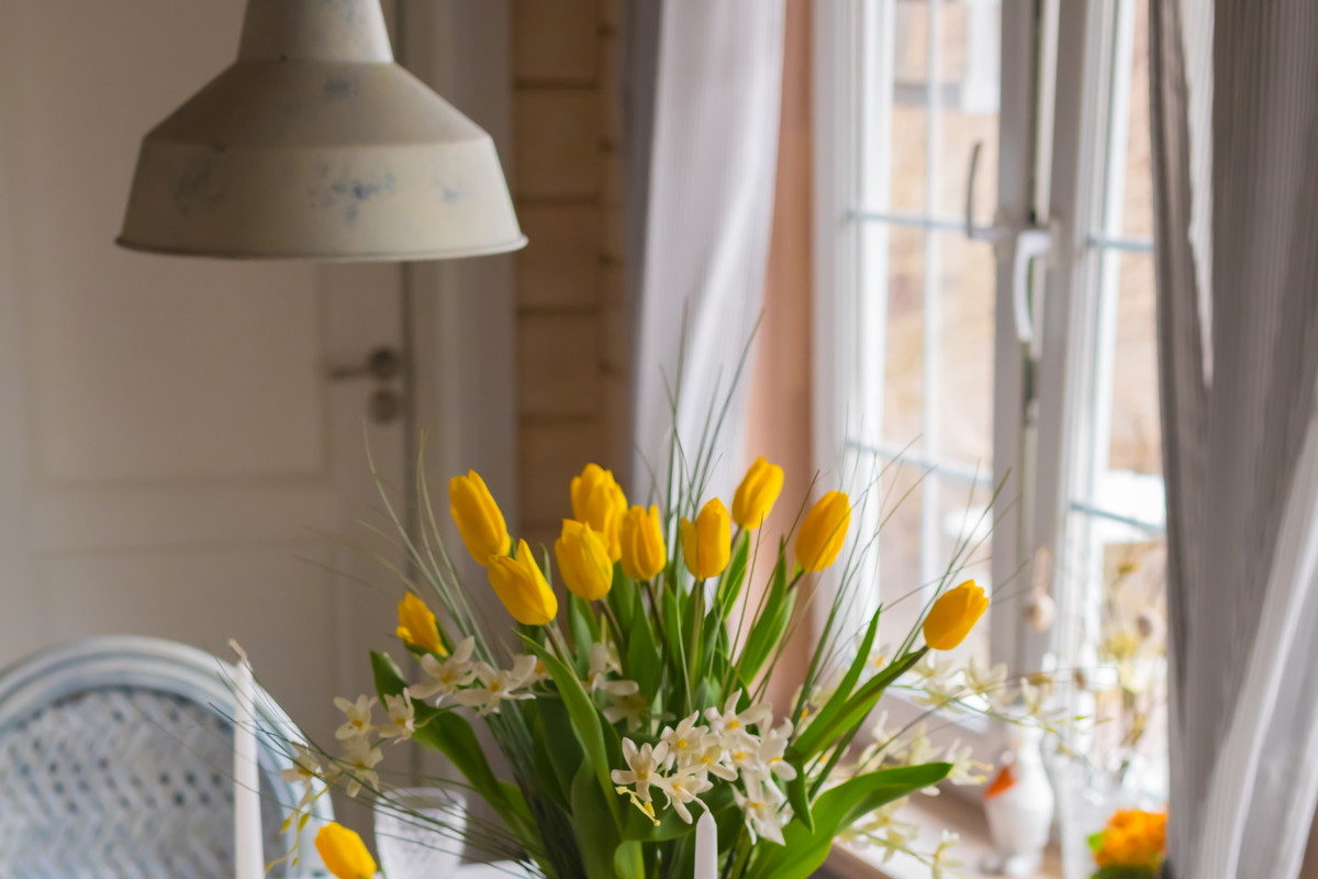 Easter festive spring table setting decoration, eggs in nest, fresh yellow tulips, marshmallows, selective focus