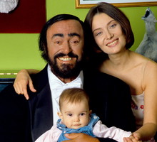 Luciano Pavarotti poses holding his daughter Alice, with his wife Nicoletta Mantovani