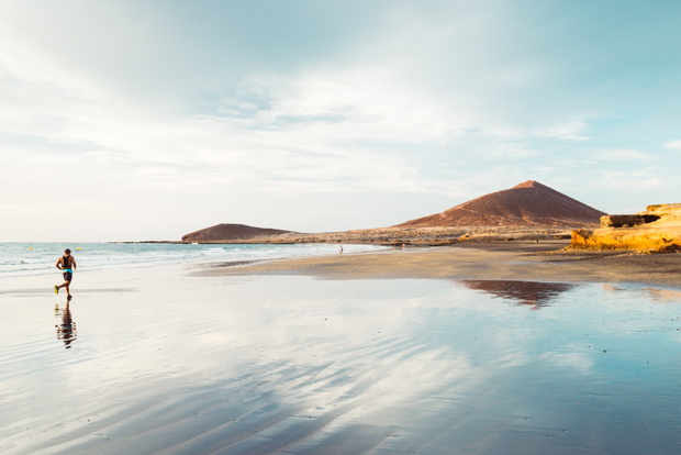 El Médano, Tenerife, Canary Islands, Spain - September 28, 2018: man running through El Médano beach, in south of Tenerife island
