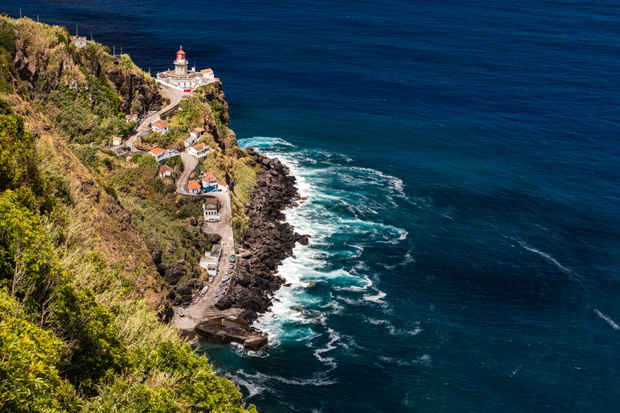 Malowniczy port i latarnia morska nad oceanem na portugalskiej wyspie São Miguel.