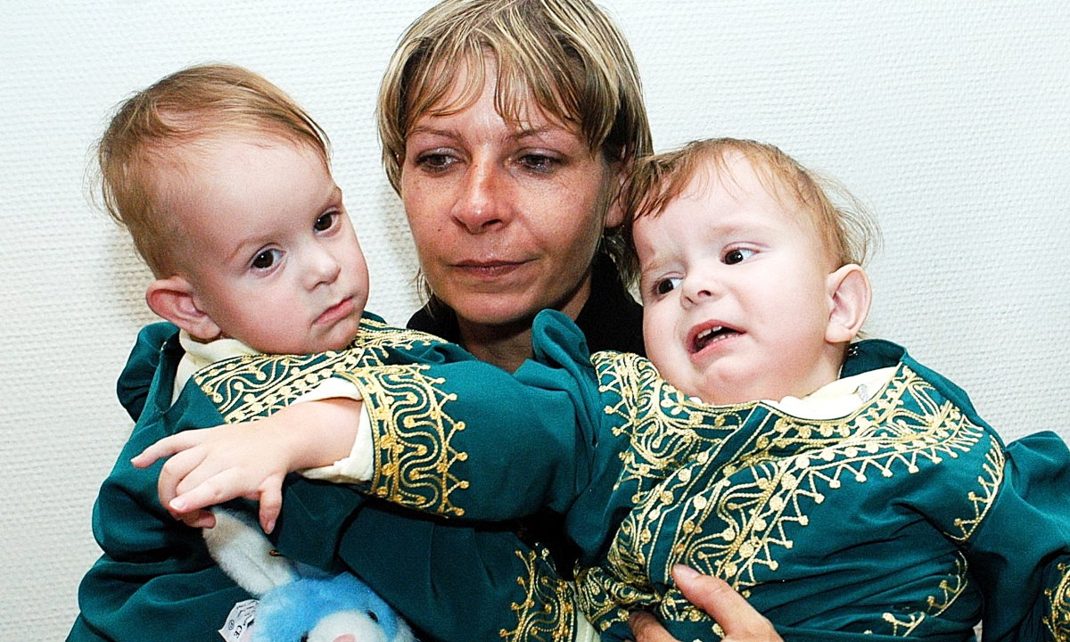22.03.05. Matka Wiesława Dąbrowska trzyma na rękach syjamskie bliźniaczki Darię (L) i Olgę Kołacz (P), które na początku stycznia 2005 r. przeszły operację rozdzielenia w Rijadzie.