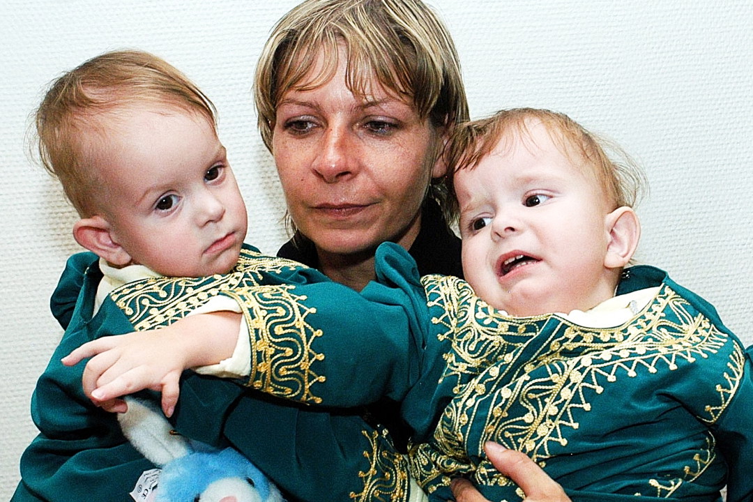 22.03.05. Matka Wiesława Dąbrowska trzyma na rękach syjamskie bliźniaczki Darię (L) i Olgę Kołacz (P), które na początku stycznia 2005 r. przeszły operację rozdzielenia w Rijadzie.