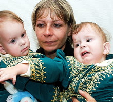 22.03.05. Matka Wiesława Dąbrowska trzyma na rękach syjamskie bliźniaczki Darię (L) i Olgę Kołacz (P), które na początku stycznia 2005 r. przeszły operację rozdzielenia w Rijadzie.