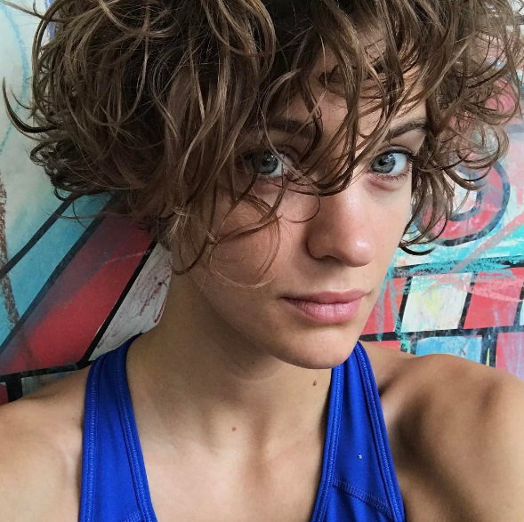Renata Kaczoruk w kręconych włosach i niebieskiej koszulce pozuje do selfie