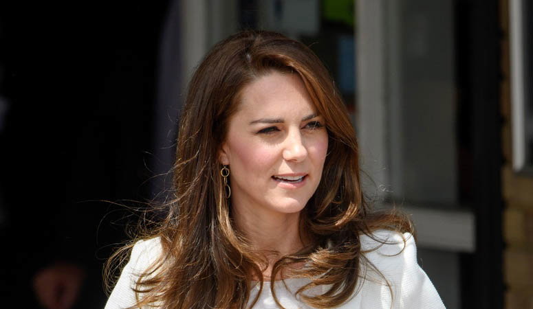 Księżna Kate w białej marynarce uśmiecha się szeroko