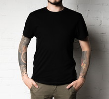 mężczyzna z tatuażami na rękach