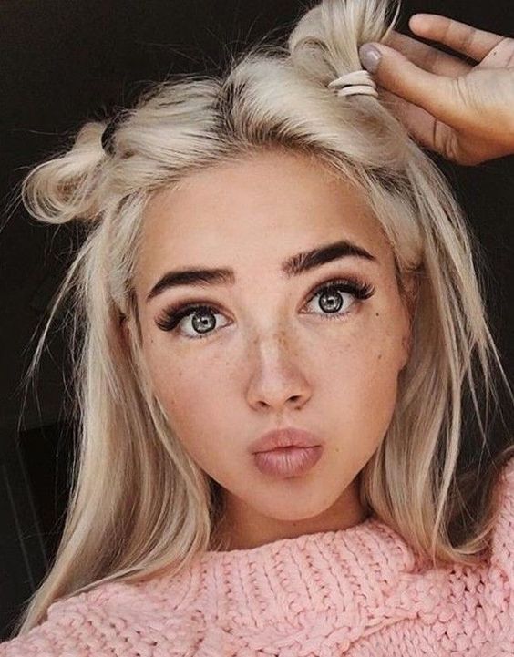 Piękna dziewczyna z krótkimi blond włosami w najmodniejszej fryzurze, czyli dwóch półkokach