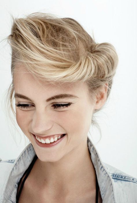 Uśmiechająca się kobieta o blond włosach we fryzurze banana bun