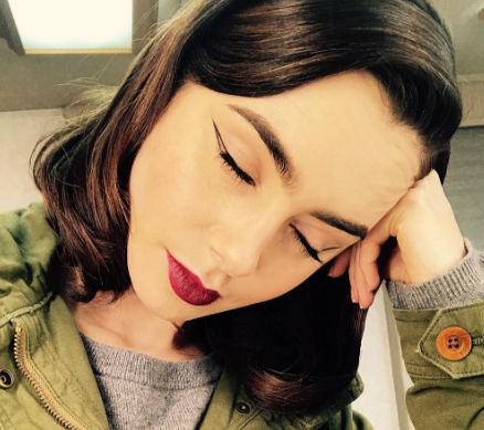 Lily Collins z zamkniętymi oczami prezentuje makijaż oczu z motywem negative space