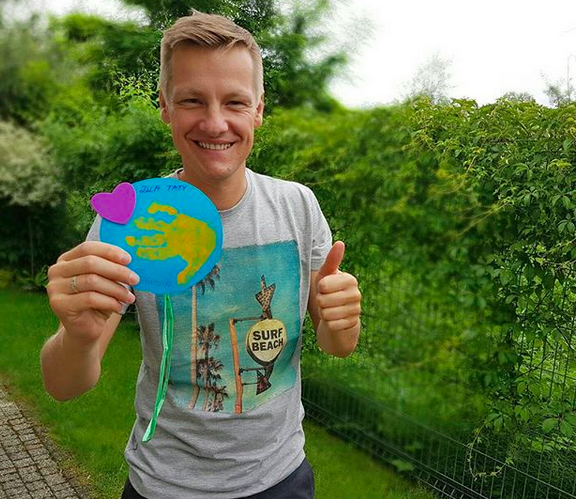 Marcin Mroczek pokazuje laurkę od swojego synka na dzień taty