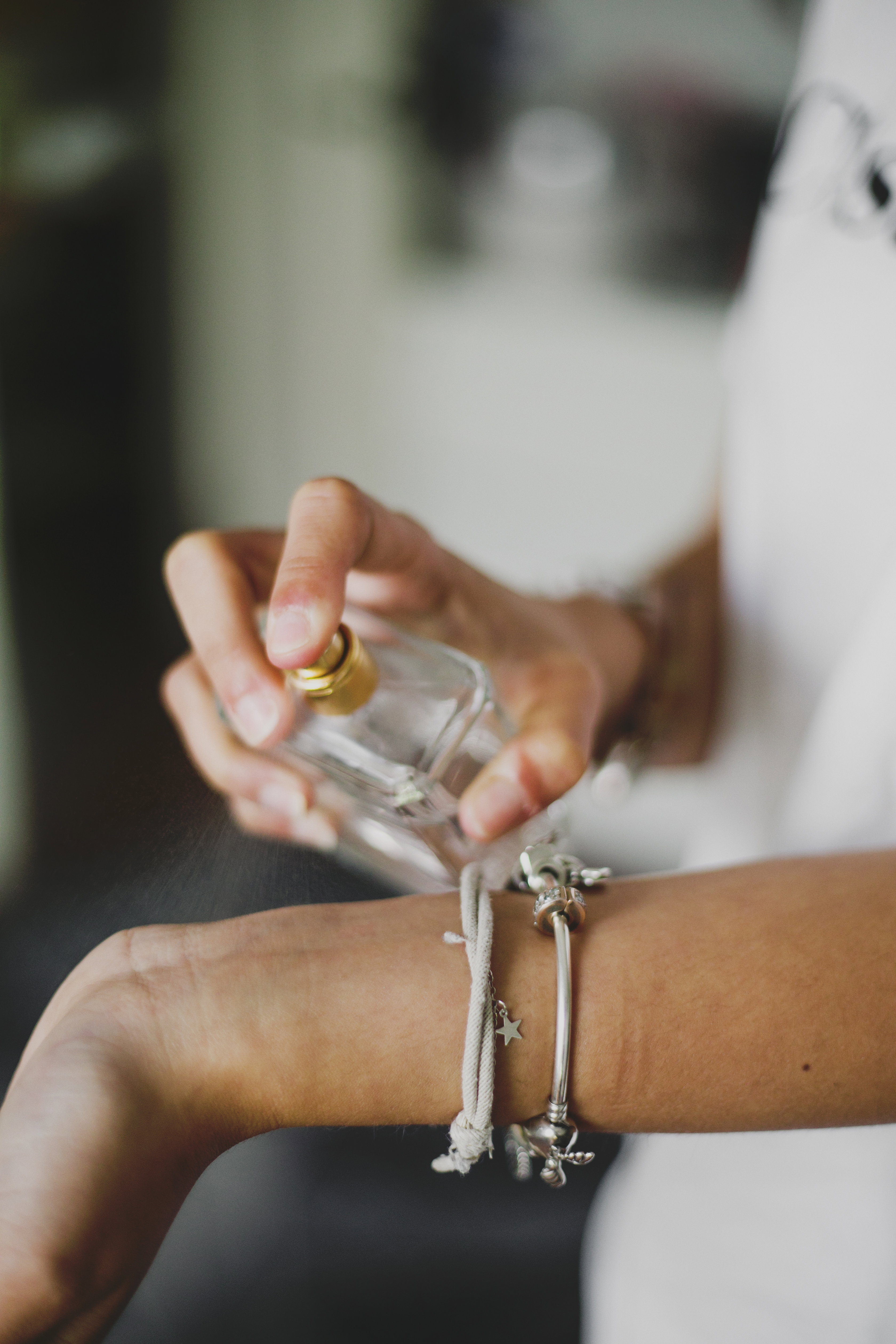 closeup woman spraying perfume on wrist