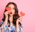 Close-up portrait of her she nice-looking attractive lovely coquettish cheerful cheery wavy-haired girl holding in hands two small little heart sending you kiss isolated over pink pastel background