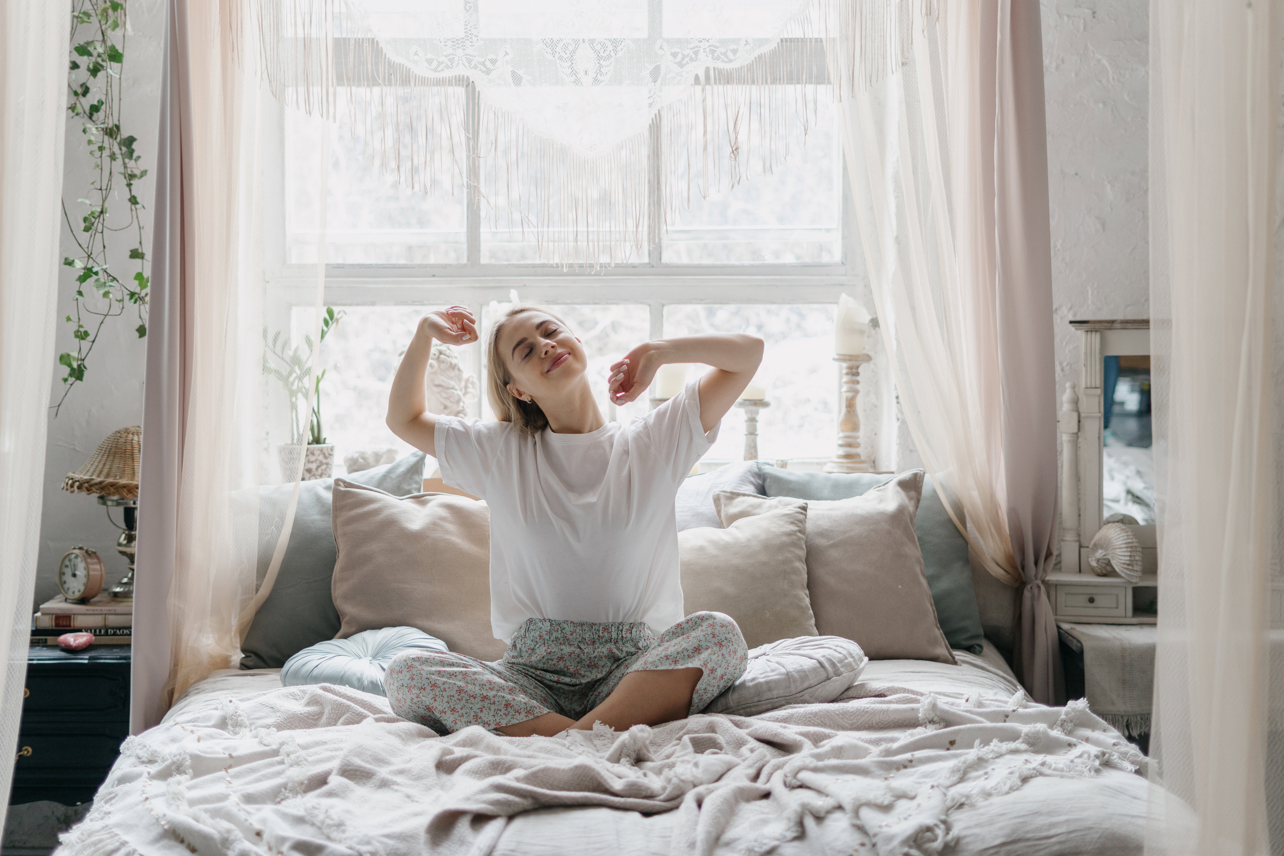 Young woman stretching in bed waking up